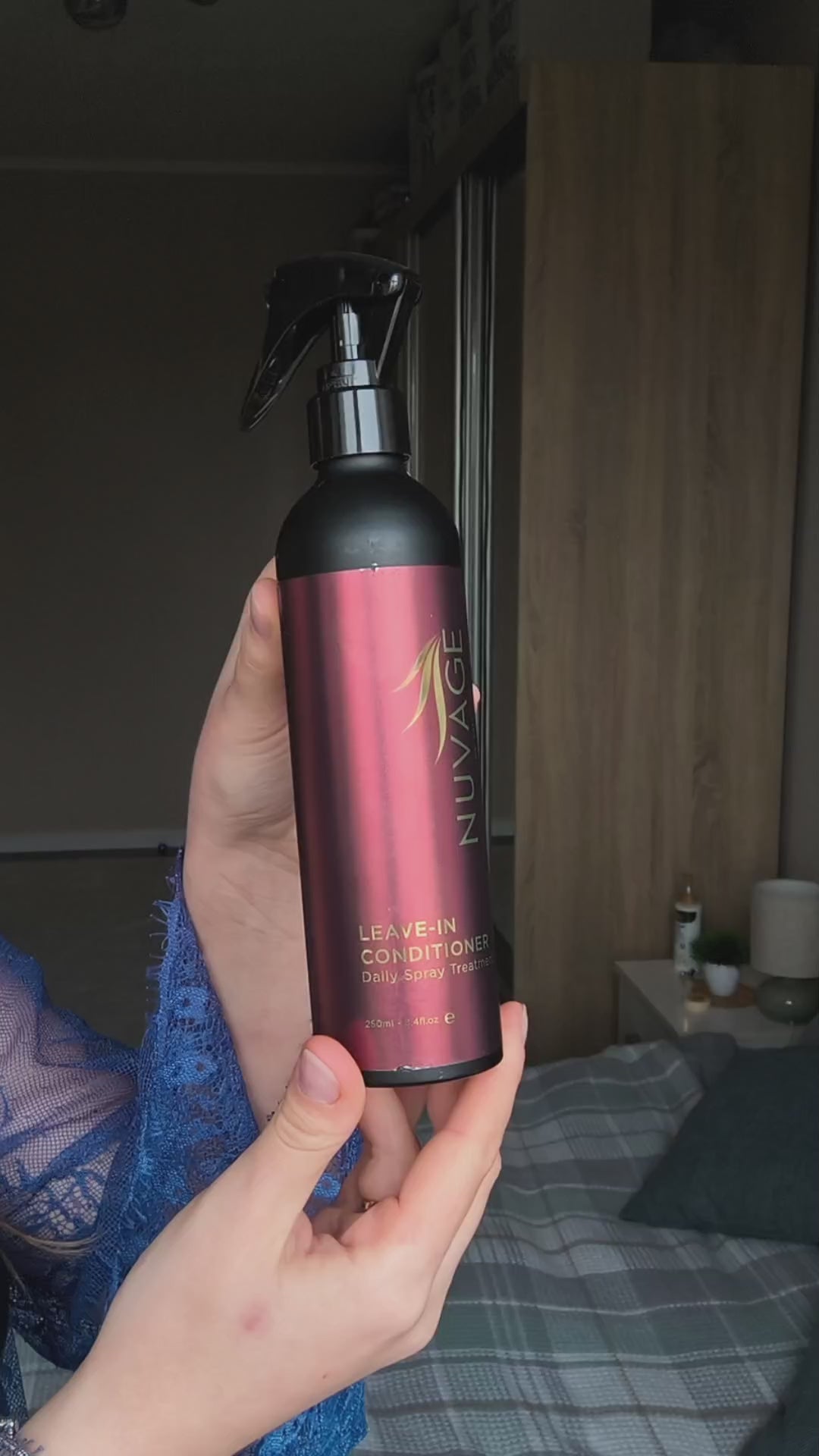 Nuvage Leave In Conditioner bottle in hand, spray-on formula for manageable hair and healthy shine.