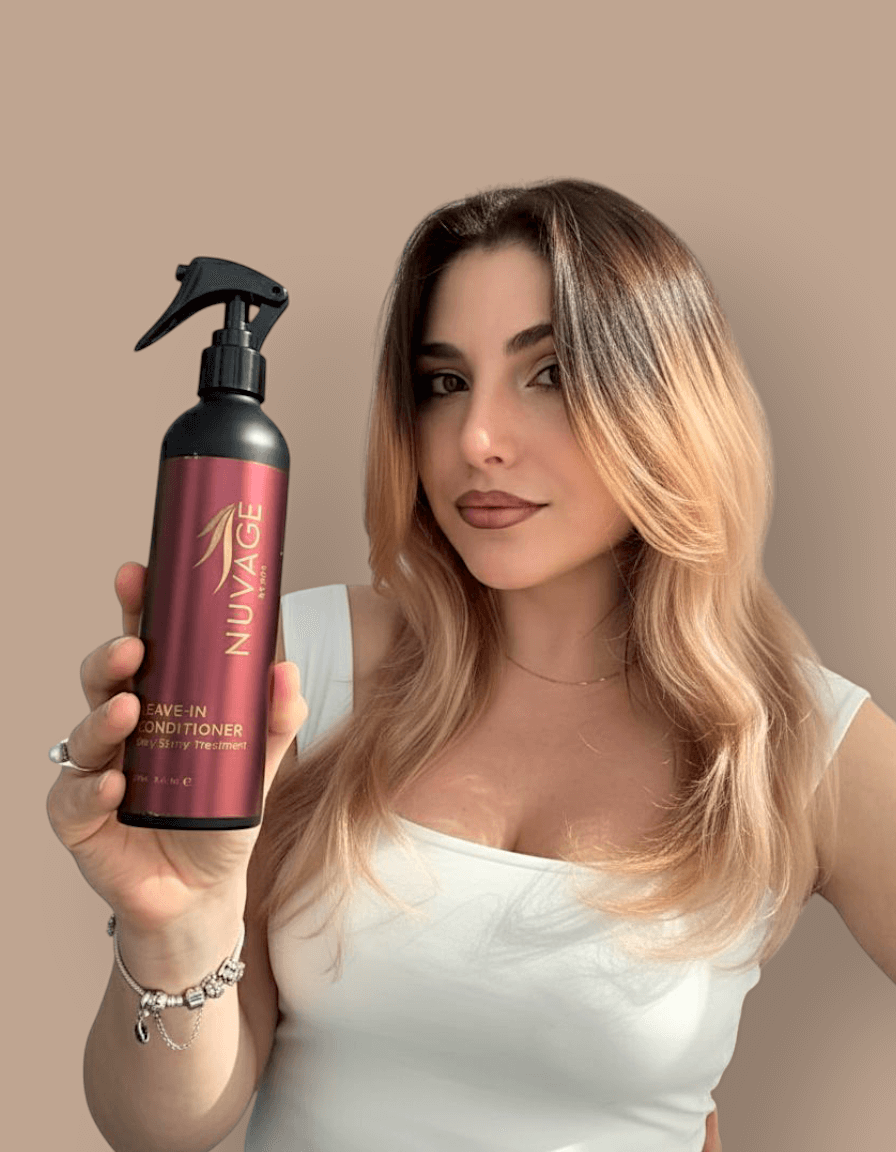 Model holding Nuvage Leave In Conditioner spray bottle, showcasing its benefits for manageable hair.